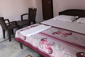 rooms Comfortable double bed room with chairs and clean accommodation at Yoganandham yoga retreat in Rishikesh.