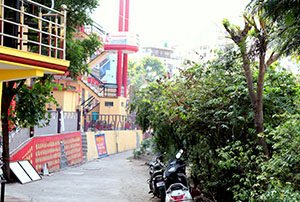 yoganandham-school Exterior view of the Yoganandham yoga school building surrounded by greenery in Rishikesh.